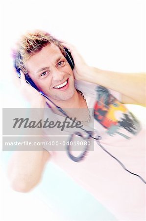 Motion blurred  portrait of young  male listening music via earphones. Focused on face.