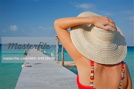 One of a large series. Woman in red bikini walking down a tropical jetty