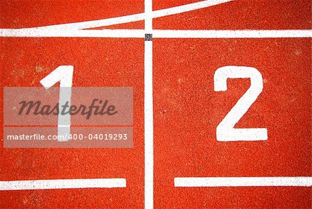 First two numbers of a racetrack, on red tarmac, for runners