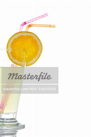 A glass of lemon juice with a slice and straws, reflected on white background