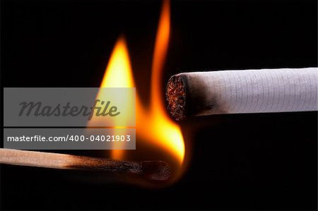 Light a cigarette with a match, black background
