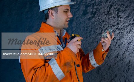 Engineer inspecting mineral with flashlight stock photo