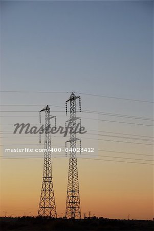 Electrical towers and wires on background sunset