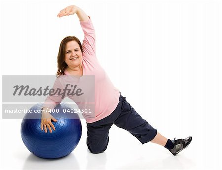 Beautiful plus sized model exercising with a pilates ball.  Full body isolated on white.