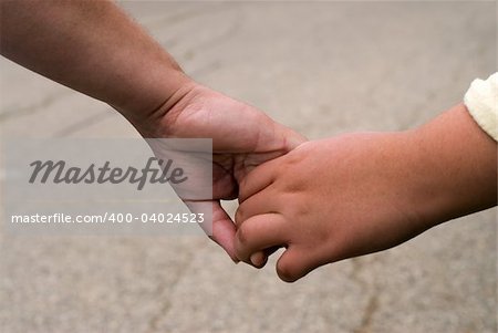 Closeup view of a mother and daughter holding hands