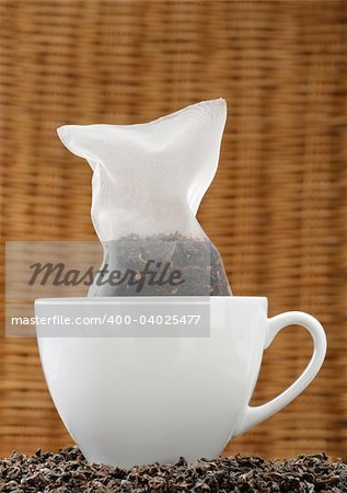 Organic tea in a corn silk tea bag in a white cup.