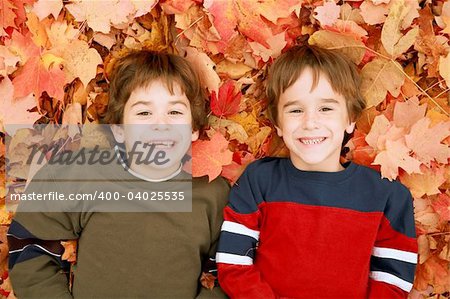 Two Boys Laying Down in the Fall Leaves