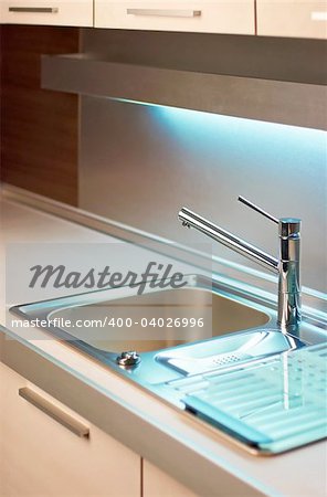 Modern stainless steel tap in white kitchen