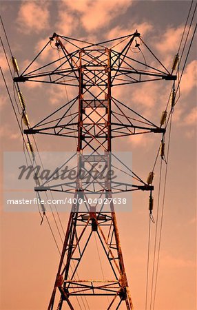 Power transmission pole against sunset skies
