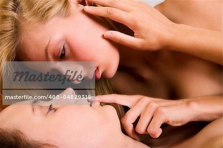 Two young lesbian girls relaxing in a bed