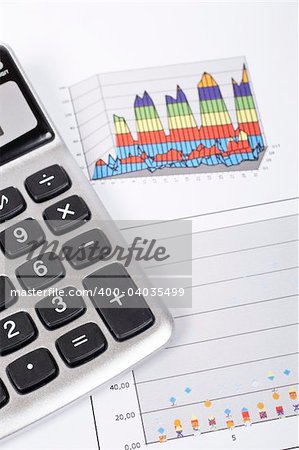 Calculator and pencil on earnings chart background. Shallow depth of field