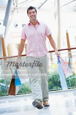 Man shopping in mall carrying bags