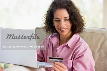 Woman making online purchase at home sitting on sofa