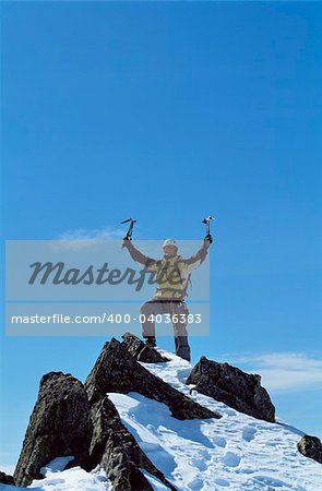 Young man celebrating reaching the top of a mountain