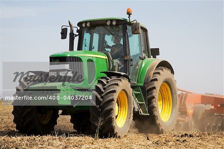 Rural scene with tractor plowing the land in autumn