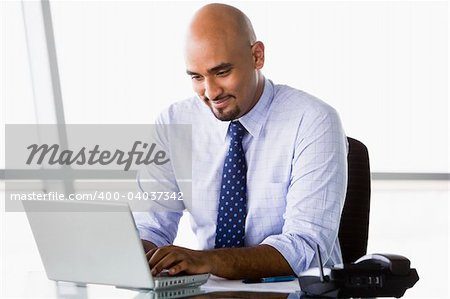 Businessman working at laptop in office