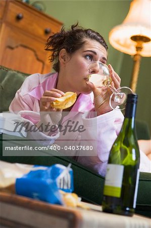 A young woman in her pyjamas drinking wine