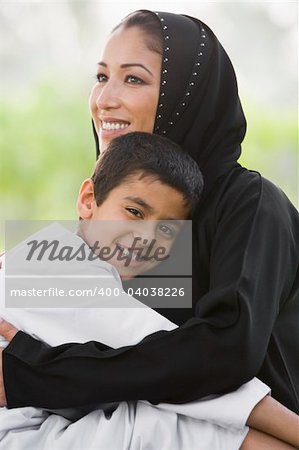 A Middle Eastern woman and her son sitting in a park