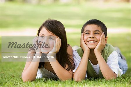 Two children relaxing in park together