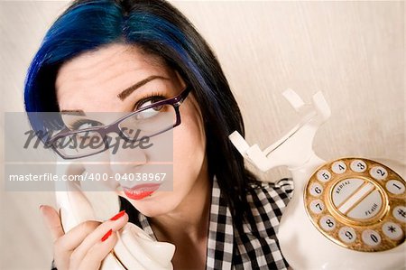 Pretty young woman talking on a vintage phone