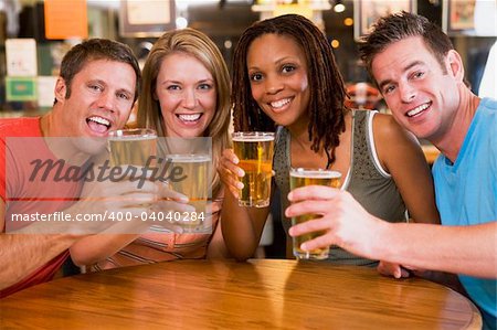 Group of young friends in bar toasting the camera