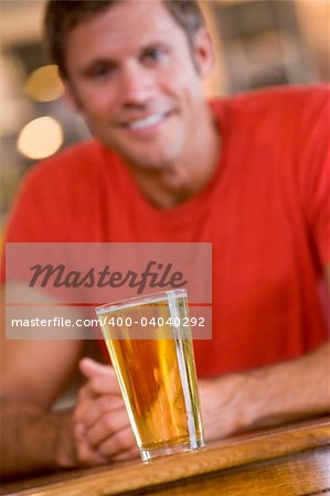 Young man relaxing at a bar with a beer