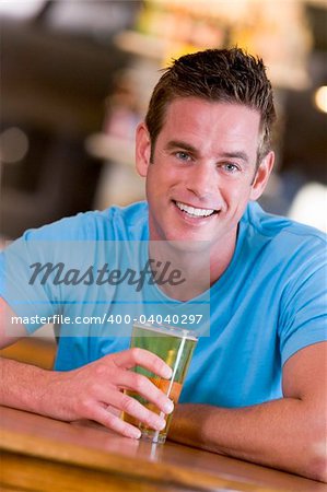 Young man enjoying a beer at a bar