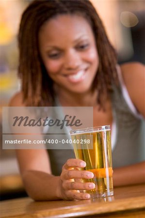 Young woman enjoying a beer at a bar