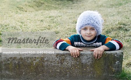 Smiling playful kid with winter white hat on his head