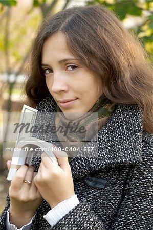 a young girl holding roll of dollars