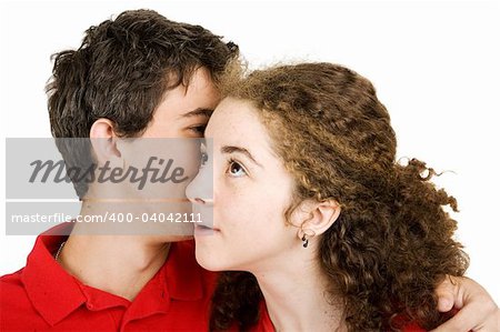 Teen girl listening to a secret whispered by her boyfriend.  Isolated on white.