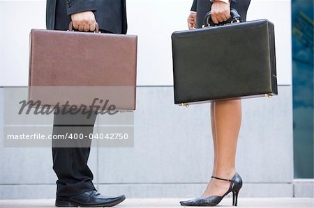 Two businesspeople holding briefcases outdoors