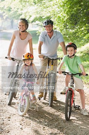 Family sitting on bikes on path smiling