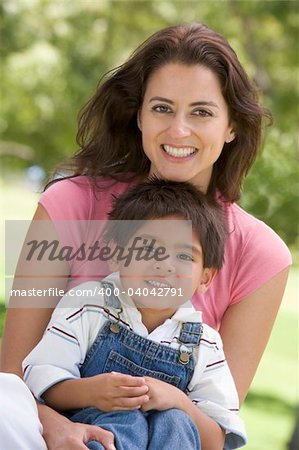 Woman and young boy sitting outdoors smiling