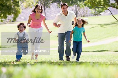 Family running outdoors smiling