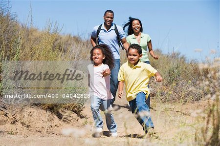 Family running on path smiling