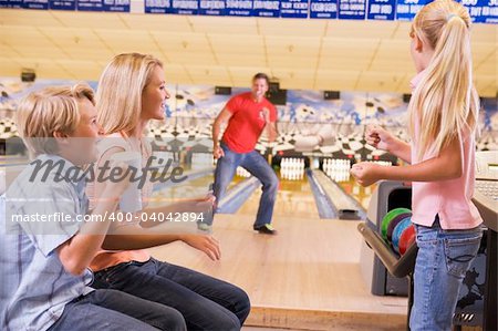 Family in bowling alley smiling