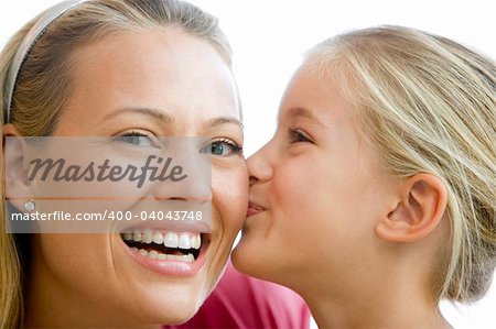 Young girl kissing smiling woman