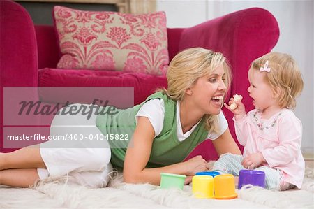 Mother in living room with baby eating banana and smiling