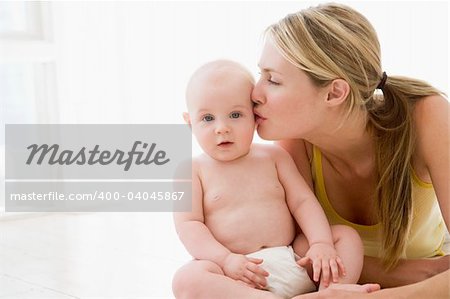 Mother kissing baby indoors