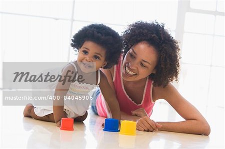 Mother and daughter indoors playing and smiling