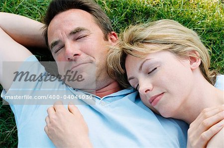 Couple lying outdoors sleeping