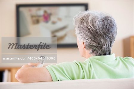 Man watching television using remote control