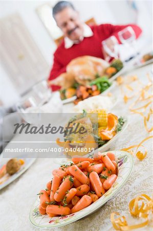 Dinner Table With Christmas Dishes,With Man In Background Carvin