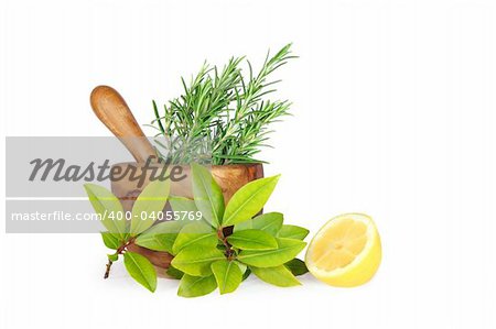 Rosemary and bay herb leaf selection with half a lemon,and an olive wood pestle and mortar. Over white background.