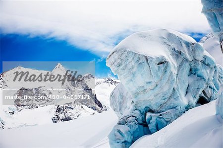 High mountain glacier over cloudy sky; in background the highest peaks of Monte Rosa (4664 mt). Zermatt, Swiss, Europe.