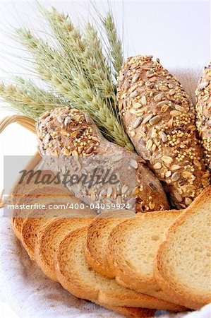 Assortment of baked bread with wheat isolated on white background