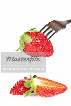 The fork pricking the strawberry isolated on white background. Shallow depth of field