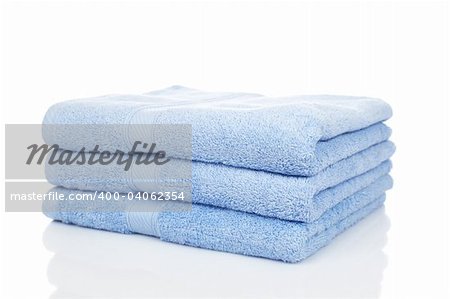 A blue towels stacked reflected on white background