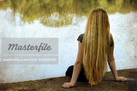 Solitude: blond woman standing alone on lakeside